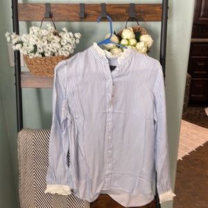 Long sleeved blue striped shirt with white ruffle trim